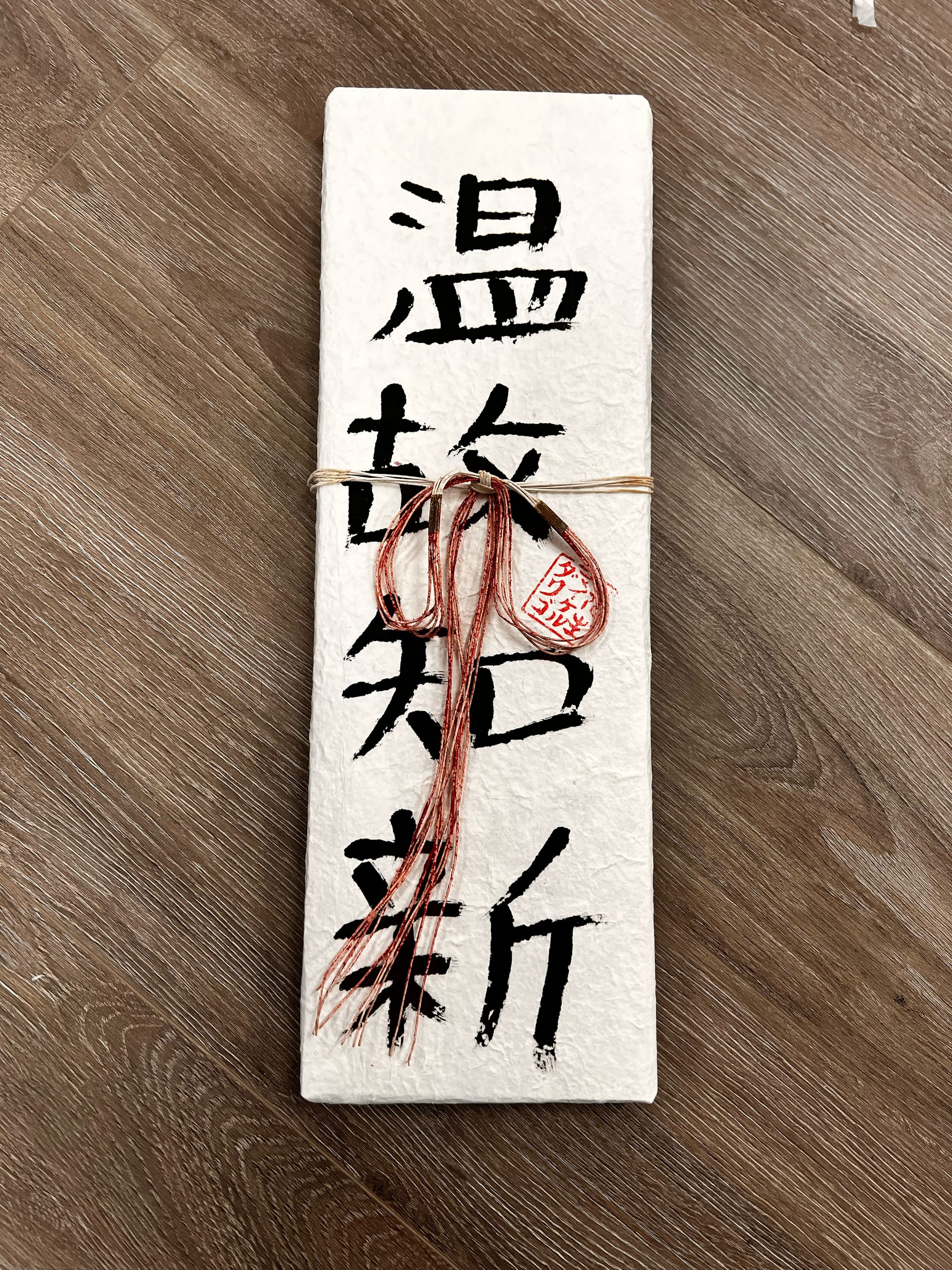 A "shikishi" board with the shodo kanji for Onkochishin 温故知新